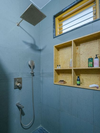 A bathroom in the Audumbara house, featuring blue Kota stone walls and a built-in shower niche made from yellow sandstone.