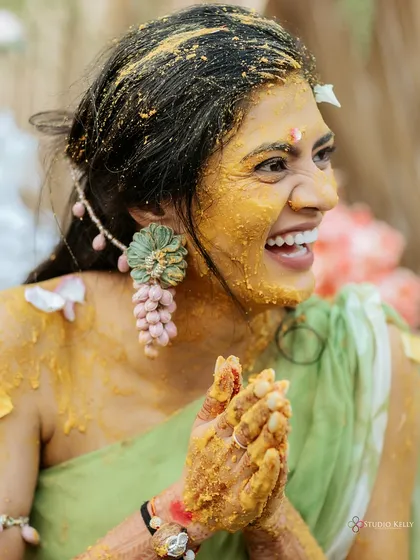 The pure joy of a Haldi ceremony in Vietnam is captured in this candid shot of the bride's infectious laughter. It’s all about capturing the real moments and the fun, desi masti of your celebrations.