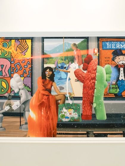 The framed "Museum Heist" artwork, a complex collage of figures like KAWS, Stitch, and a woman in a flowing orange dress holding a custom-painted luxury bag.