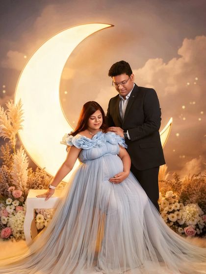Another angle of our popular moon prop setup. The Elsa gown's flowing fabric and the dreamy background create a truly unforgettable maternity photograph.