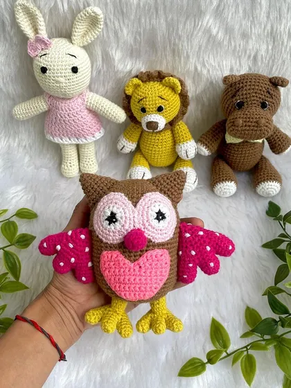 A collection of animal friends made as newborn photo props. This set includes a colorful owl, a lion, a hippo, and a bunny.