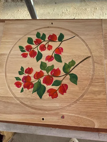 Bright red bougainvillea flowers painted on a wooden board. The natural grain of the wood provides a beautiful, rustic background for the artwork.