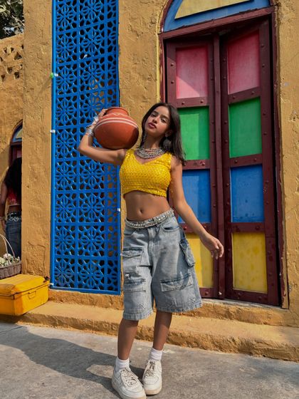 Holding a traditional pot (matka) in a playful pose, blending traditional elements with a modern, urban style.