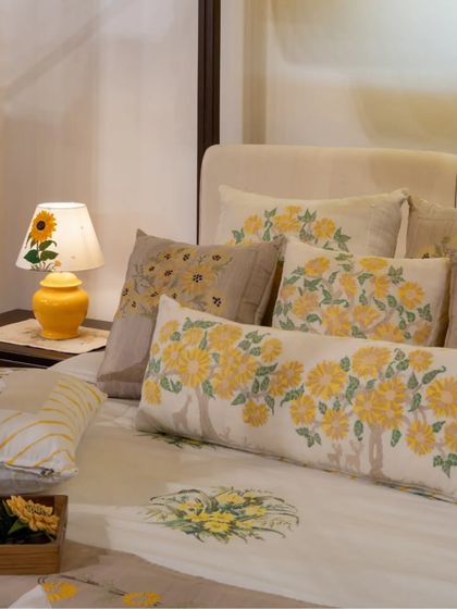 The beautiful, hand-embroidered floral patterns on the pillows add a layer of delicate artistry to the bed, showcasing the power of our collaboration with textile artisans.