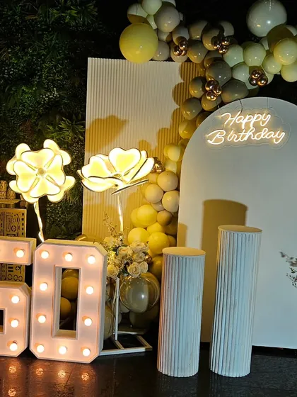 A complete view of the elegant 50th birthday photo booth area. We combine different elements like backdrops, balloons, marquee lights, and props to create a cohesive and impressive look.