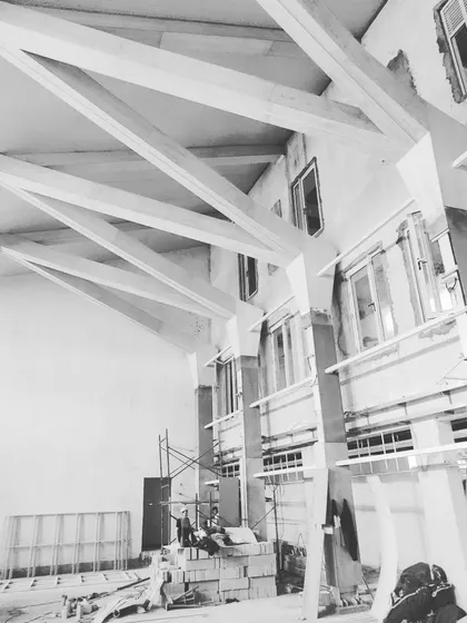 A three-dimensional diagrid roof structure during its installation phase. This prefabricated steel framework, later clad in ash wood, is an example of the advanced structural systems I employ in my designs for both aesthetic and functional purposes.