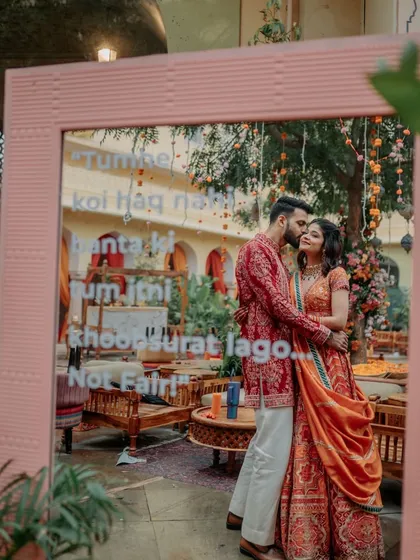 A creative shot of the couple reflected in a mirror with a quirky quote, capturing the fun and romance of their celebration.