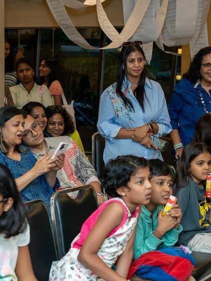 The audience, a mix of students, parents, and art lovers, watches a presentation during our exhibition opening. We foster a strong community, and our annual show is a testament to that supportive environment.