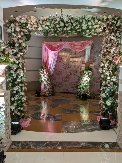 This entrance was designed to feel like walking into a classic romance. Ornate pillars, grand floral urns, and a soft pink color palette created a timeless and elegant welcome.