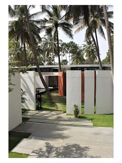 A view of the Akriti Experience Centre, where the architecture frames and interacts with the mature palm trees on the site.