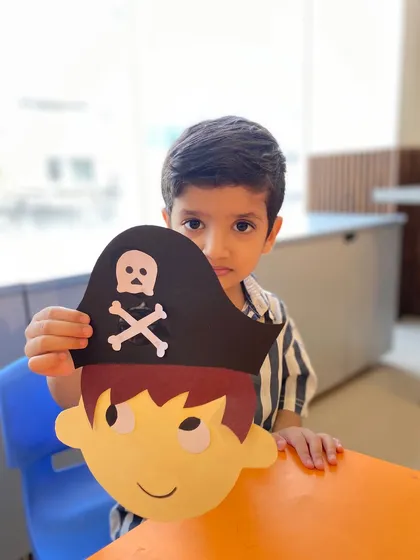 This boy peeks out from behind his pirate mask, engaging in a bit of playful character work.