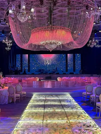 An opulent setting of chandeliers, dreamy lights, and floral details. The illuminated glass walkway and massive crystal ceiling installation set the perfect stage for a night of unforgettable celebrations. 🪩💜