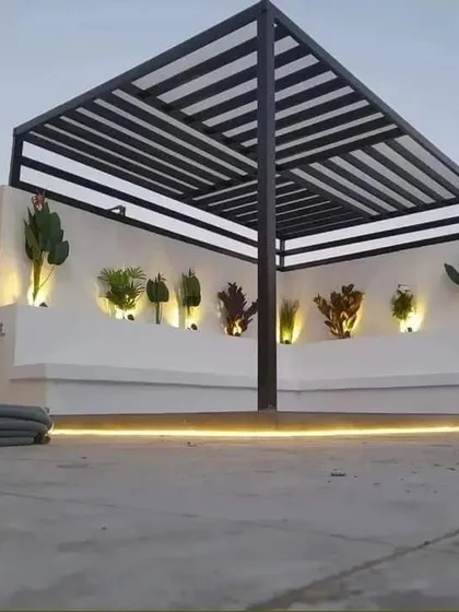 A minimalist raised platform under a pergola, with the floor and surrounding area finished in concrete. The design is accented by a single line of LED lighting at the base.