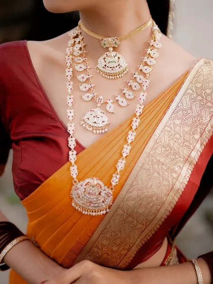 Details matter. This close-up highlights the exquisite craftsmanship of the bride's layered temple necklaces against the texture of her silk saree, a key part of the South Indian bridal story.