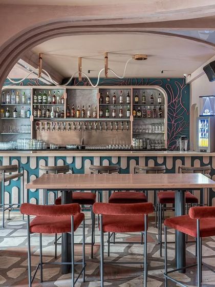 Another perspective of the bar and high-top seating at Hangover. The combination of terrazzo floors, pastel walls, and bold patterns creates a unique and memorable interior.
