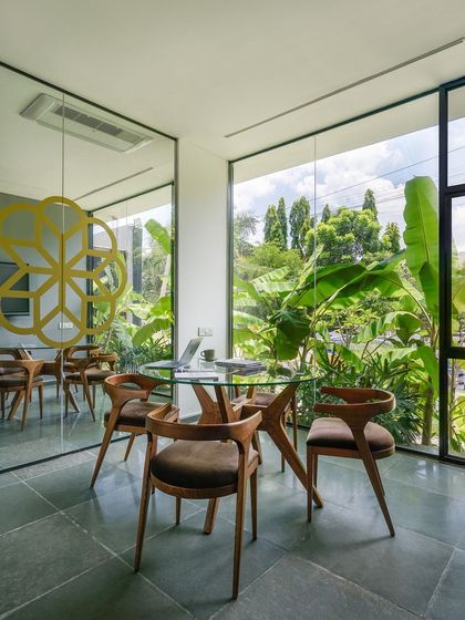 A duplicate view of the garden-facing discussion room, highlighting the elegant furniture and the reflection of the outdoor space in the mirrored wall.