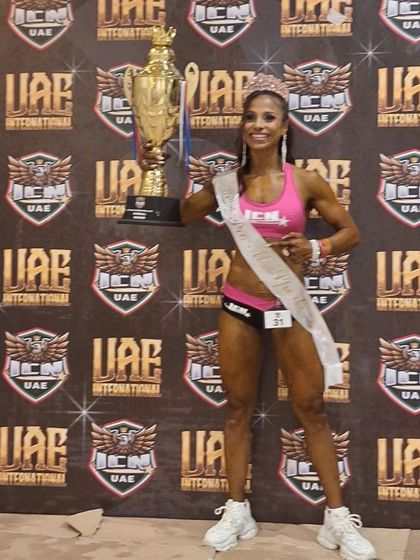 My client celebrating her Pro win at the ICN Dubai International. This trophy represents her dedication and our successful coaching partnership.