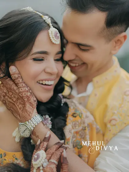 A close-up of pure bliss during a Haldi ceremony. The groom's hand gently caressing her face and their shared smiles create a moment of incredible warmth and intimacy.