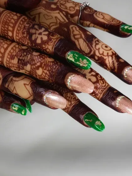 This design was created to match a specific wedding outfit, using a vibrant green polish with gold foil accents alongside a shimmering neutral color.