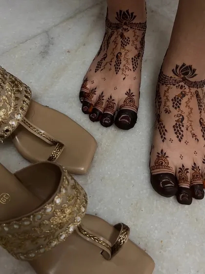 This photo shows how beautifully the peacock and vine foot design pairs with traditional footwear. The henna acts as a permanent, beautiful accessory.