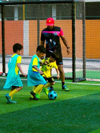 A coach guides our youngest players through a drill, ensuring they learn the basics correctly.