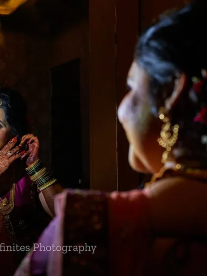 A lovely candid moment captured during the getting-ready process. The reflection in the mirror adds a nice compositional layer to the portrait.
