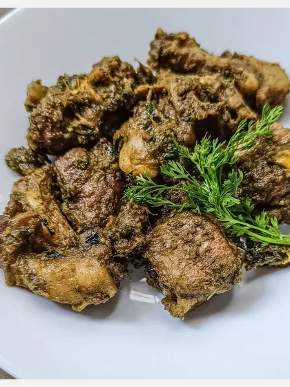 A close-up of the Karnivore Bannur Mutton Fry, garnished with fresh coriander.