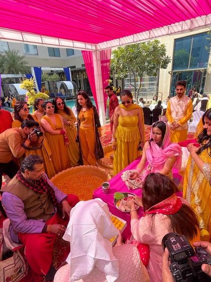 The Haldi ceremony in full swing. This photo shows the vibrant setup and the bride surrounded by family, ready for the rituals.