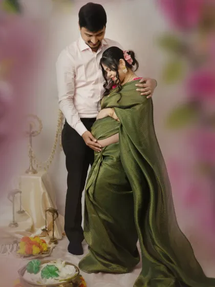A standing portrait that captures the couple's connection. The husband gently holds his wife as she cradles her bump, a classic and emotional pose that celebrates their journey together.