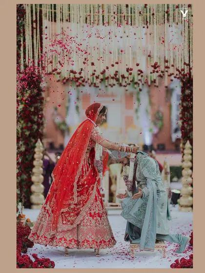 The beautiful chaos of a varmala ceremony, frozen in a shower of rose petals. This is a key ritual, and we capture it from a perspective that highlights the action, the emotion, and the vibrant energy of the moment.