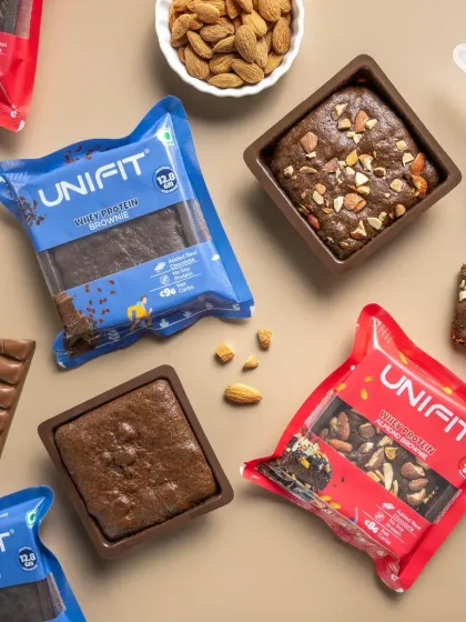 A flat lay of different whey protein brownie packets, showing the product variety and texture.