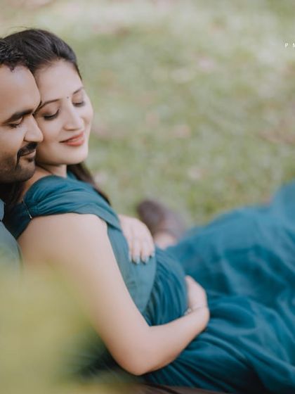 An intimate close-up from a maternity session. The deep teal fabric of the gown drapes beautifully, adding a rich texture and color to this tender couple's portrait.