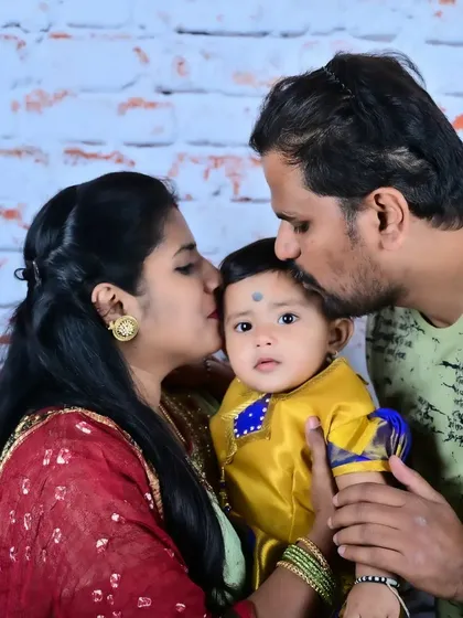 A close-up of parents kissing their baby's head, a beautiful expression of family love.
