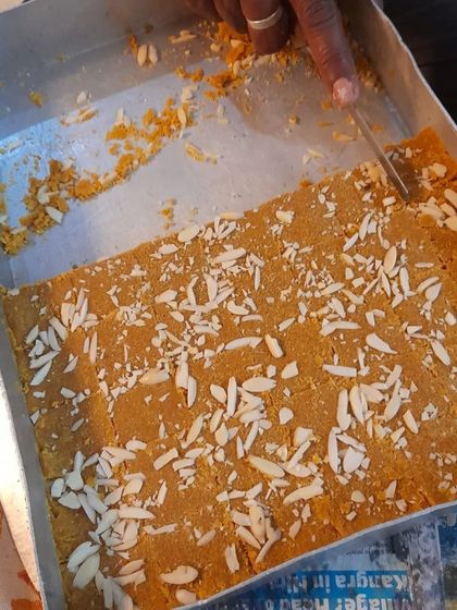 The process of making Besan Barfi. Here, I am cutting the freshly set barfi into neat squares before packing.