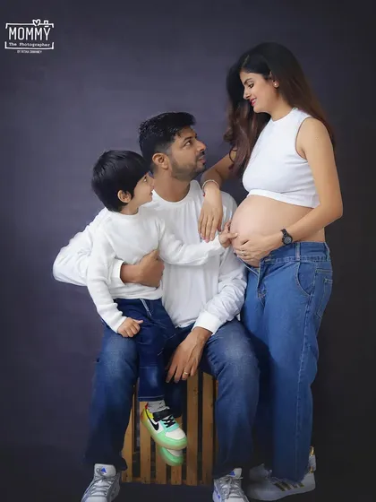 A candid family moment in the studio. The older brother curiously talks to the baby bump, creating a genuine and heartwarming memory for this growing family.