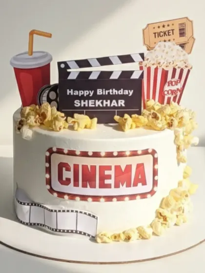 Lights, camera, cake! This cinema-themed birthday cake was a super fun project for a Bollywood fan. It’s a homemade eggless strawberry vanilla cake, complete with edible popcorn, a movie ticket, and a clapperboard.