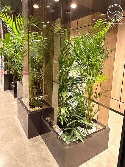 The interplay of light, reflection, and greenery at The Executive Centre, Hyderabad. The mirrored pillars and strategic lighting make the planters a central feature of the design.