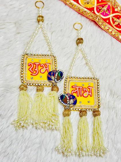 This bright and cheerful Shubh Labh set features yellow squares with peacock details. The pearl strings and beaded tassels make it a delicate and beautiful choice for your door.
