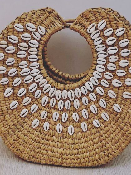 This stylish and eco-friendly seagrass beach bag is a must-have holiday accessory. Its spacious interior, sturdy handles, and beautiful cowrie shell detailing make it perfect for carrying all your essentials with a touch of natural beauty.
