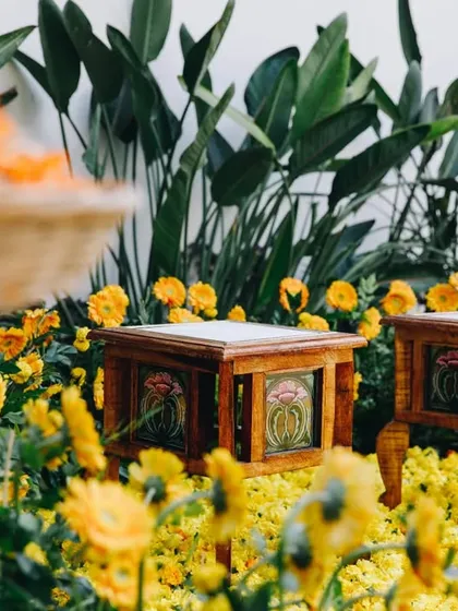 Hand-painted stools and lush greenery add detail to this intimate Haldi decor. We love incorporating artisanal and handcrafted elements into our designs.