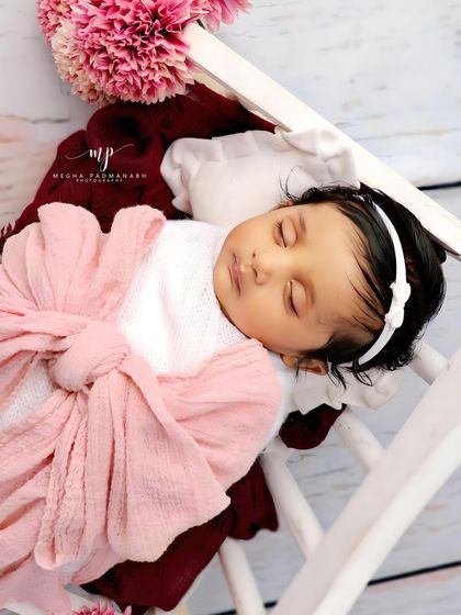 A close-up on the baby's face, showing her delicate features and the soft lighting.