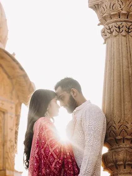 A beautiful, sun-kissed moment from a Jaisalmer pre-wedding shoot. The makeup is soft and romantic, with warm tones to complement the golden light and historic architecture. The hair is styled in loose waves for an effortless feel.