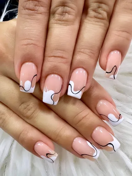 Soft, subtle, and classic with a twist. This design uses abstract white and black lines to create a unique, artistic take on the traditional French tip.