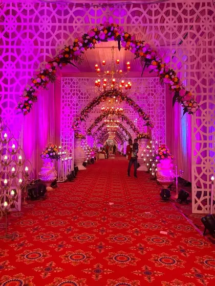 A slightly different angle of the grand purple entrance, highlighting the candle-like light installations and floral arrangements that line the path.