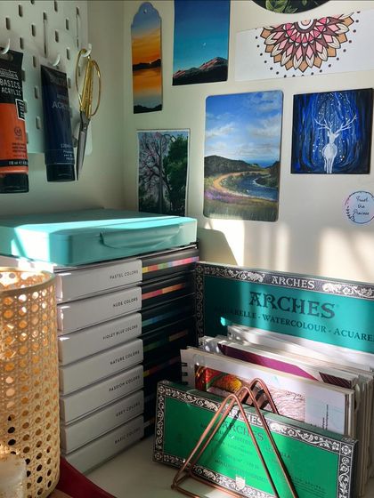 A corner of my studio with my art supplies and some of my paintings.