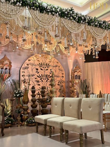 A closer look at the side of the stage, highlighting the plush seating, traditional brass decor, and the beautiful lotus-cutout backdrop.