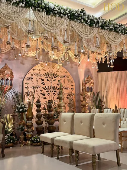 A closer look at the side of the stage, highlighting the plush seating, traditional brass decor, and the beautiful lotus-cutout backdrop.