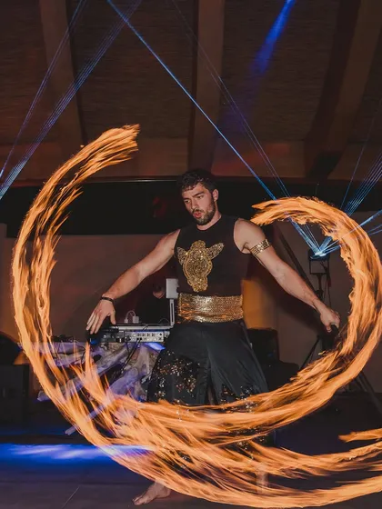 A fire dancer captivates the audience with his daring and mesmerizing performance. This is perfect for adding a 'wow' factor to an evening event.