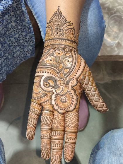 A single-hand Arabic design with a large, intricate central motif. This style is perfect for someone who wants a beautiful but not overpowering mehandi.