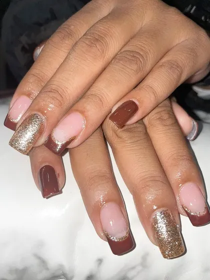 A warm and cozy set with brown French tips and gold glitter accent nails.